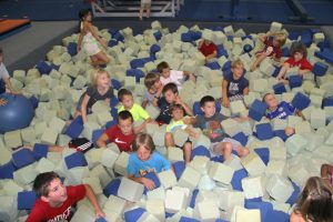 A group of campers plays in the foam pit