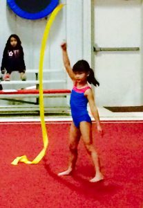 A young gymnast works with a ribbon