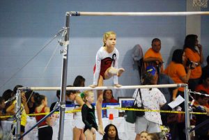 A girl competes on the uneven bars