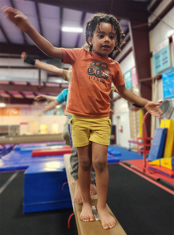cp2 Child balances confidently on a beam during gymnastics class at Carolina Gymnastics Academy.